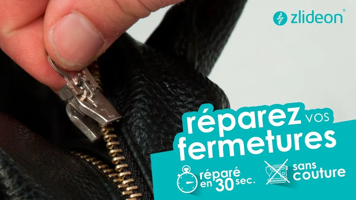 Gros plan sur une main qui tient une fermeture éclair abîmée d’un manteau, outils de couture posés à côté
